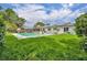 Lush backyard with an in-ground pool, screen enclosed lanai, solar panels, and fencing at 320 Bridle Path, Casselberry, FL 32707
