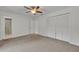 Bedroom showcasing a ceiling fan, carpeted floor, and an adjacent ensuite bathroom at 320 Bridle Path, Casselberry, FL 32707