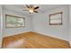 Bright bedroom boasts gleaming hardwood floors, two windows, and a ceiling fan at 320 Bridle Path, Casselberry, FL 32707