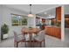 Bright dining area with a round table, chairs, and view of landscaped backyard through a large window at 320 Bridle Path, Casselberry, FL 32707