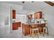 Kitchen island with granite countertops, wood cabinets, and bar stool seating overlooking the living area at 320 Bridle Path, Casselberry, FL 32707
