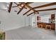 Spacious living area featuring vaulted ceilings, exposed beams, and an open layout to the kitchen at 320 Bridle Path, Casselberry, FL 32707