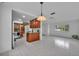 Open concept living room with tile flooring, pendant lighting, and a view into the updated kitchen at 320 Bridle Path, Casselberry, FL 32707