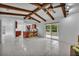 Open floorplan with vaulted ceilings, wood beams, kitchen view, and access to outdoor lanai at 320 Bridle Path, Casselberry, FL 32707