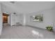 A sunlit living room boasting tile floors, a large window, and neutral wall paint at 320 Bridle Path, Casselberry, FL 32707