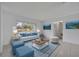 Bright living room featuring a white couch, blue accents and tile flooring at 320 Bridle Path, Casselberry, FL 32707