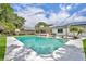 Backyard with in-ground pool, sun shade, solar panels, and lush landscaping at 320 Bridle Path, Casselberry, FL 32707