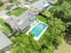 Overhead view of a backyard pool and patio with manicured lawn, solar panels, and a screened-in porch at 320 Bridle Path, Casselberry, FL 32707
