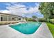 Backyard featuring an in-ground pool, sun shade, and lush landscaping at 320 Bridle Path, Casselberry, FL 32707