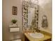 Stylish bathroom featuring a decorative mirror, granite countertops, and wall decorations at 322 Annabelle Way, Davenport, FL 33837