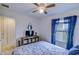 Cozy bedroom with stylish blue accents, ceiling fan, and natural light from the window at 322 Annabelle Way, Davenport, FL 33837