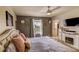 Comfortable bedroom featuring stylish decor, a ceiling fan, and a window with a pleasant view at 322 Annabelle Way, Davenport, FL 33837