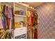 Walk-in closet with organized shelving and hanging space with stylish geometric wallpaper at 322 Annabelle Way, Davenport, FL 33837