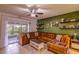 Cozy living room with plush seating, ceiling fan, and sliding glass doors to the outdoor patio at 322 Annabelle Way, Davenport, FL 33837