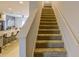 Carpeted staircase connecting to a well-lit kitchen featuring granite countertops and modern bar stools at 322 Annabelle Way, Davenport, FL 33837
