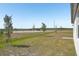 The large, grassy backyard of the new home is complemented by newly planted trees at 3253 Viceroy Ct, Poinciana, FL 34759