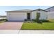 Charming single-story home featuring a brick driveway, well-maintained lawn, and neutral-toned exterior at 3253 Viceroy Ct, Poinciana, FL 34759