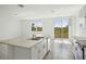 Bright kitchen features an island with a double sink and a sliding glass door to the backyard at 3253 Viceroy Ct, Poinciana, FL 34759