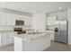 Modern kitchen boasts stainless steel appliances, white cabinets, and a central island with a sink at 3253 Viceroy Ct, Poinciana, FL 34759