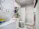 Bathroom featuring modern washer and dryer, standing shower and sleek white finishings at 3325 Horseshoe Dr, Longwood, FL 32779