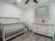 Bright Bedroom features hardwood floors, ceiling fan, crib and white dresser with changing top at 3325 Horseshoe Dr, Longwood, FL 32779