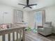 Charming Bedroom with hardwood floors, ceiling fan, rocker and a crib with a whimsical design at 3325 Horseshoe Dr, Longwood, FL 32779