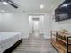 Spacious bedroom featuring a sleek TV, a wooden shelf, and open entryway at 3325 Horseshoe Dr, Longwood, FL 32779