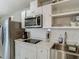 Close-up of kitchen features stainless steel appliances, white cabinets and an undermount sink at 3325 Horseshoe Dr, Longwood, FL 32779