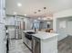 Open kitchen with stainless steel appliances, island seating, and a view to the dining and living spaces at 3325 Horseshoe Dr, Longwood, FL 32779