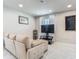 Cozy living room with a comfortable beige sofa, marble tile floors and minimalist decor at 3325 Horseshoe Dr, Longwood, FL 32779