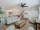 Bright living room featuring stylish furniture, a ceiling fan, and open layout to the kitchen and dining areas at 3325 Horseshoe Dr, Longwood, FL 32779