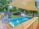 Backyard pool with shade structure, outdoor seating, trampoline and well-manicured lawn at 3325 Horseshoe Dr, Longwood, FL 32779
