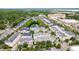 An aerial view of residences and businesses with mature trees and an attractive pond feature at 338 Roberts Family Ln, Winter Springs, FL 32708