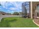 A lush green backyard showcases a modern enclosed patio and a white fence for privacy and security at 3656 Heirloom Rose Pl, Oviedo, FL 32766