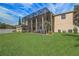 Well-maintained backyard with lush lawn, an enclosed patio, air conditioning units, and neatly trimmed palm trees at 3656 Heirloom Rose Pl, Oviedo, FL 32766