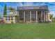 A spacious backyard featuring manicured lawn and an enclosed patio area with a hot tub for outdoor relaxation at 3656 Heirloom Rose Pl, Oviedo, FL 32766
