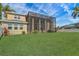 Expansive backyard featuring lush green grass, a screened-in enclosure, and a view of the sky at 3656 Heirloom Rose Pl, Oviedo, FL 32766
