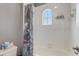 Bright bathroom features a shower-tub combination with an arched window at 3656 Heirloom Rose Pl, Oviedo, FL 32766