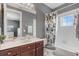 Bathroom features dark wood vanity, framed mirror, and tub/shower combo with a modern shower curtain at 3656 Heirloom Rose Pl, Oviedo, FL 32766