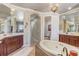 Open bathroom featuring mosaic tub, double vanity sinks, and an archway into the toilet area at 3656 Heirloom Rose Pl, Oviedo, FL 32766