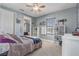Cozy bedroom features large window, ceiling fan, light gray walls, carpet flooring, and white shelving units at 3656 Heirloom Rose Pl, Oviedo, FL 32766