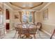 Formal dining room with decorative chandelier, tray ceiling, updated flooring, and large window offering views at 3656 Heirloom Rose Pl, Oviedo, FL 32766