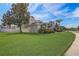 The lush front lawn complements the two-story house, surrounded by diverse trees and manicured shrubs at 3656 Heirloom Rose Pl, Oviedo, FL 32766