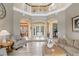 Bright foyer features soaring ceilings, columns, hardwood floors, and inviting doorway leading to other living spaces at 3656 Heirloom Rose Pl, Oviedo, FL 32766