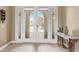 Elegant double front doors with sidelights, complemented by decorative sconces and foyer at 3656 Heirloom Rose Pl, Oviedo, FL 32766
