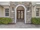 Elegant stone entryway with a double door and manicured bushes at 3656 Heirloom Rose Pl, Oviedo, FL 32766