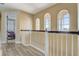 Hallway showcases natural light through arched windows and a view of the bedroom and wooden floors at 3656 Heirloom Rose Pl, Oviedo, FL 32766