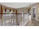 Hallway overlooks the living area with views of the pool and patio through large windows and custom curtains at 3656 Heirloom Rose Pl, Oviedo, FL 32766