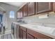 Well-equipped laundry room features overhead cabinets, ample counter space, and modern washer and dryer at 3656 Heirloom Rose Pl, Oviedo, FL 32766