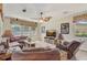Comfortable living room boasts a large sectional, a ceiling fan, and natural light through large windows at 3656 Heirloom Rose Pl, Oviedo, FL 32766